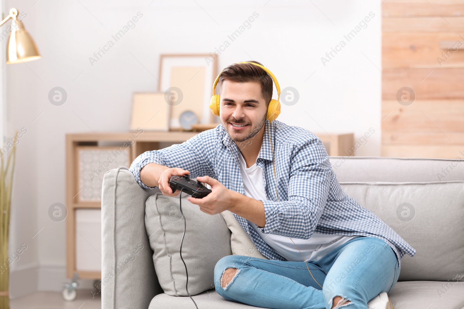 Photo of Emotional young man playing video games at home