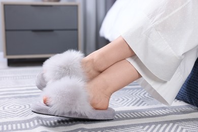 Photo of Woman in grey soft slippers at home, closeup