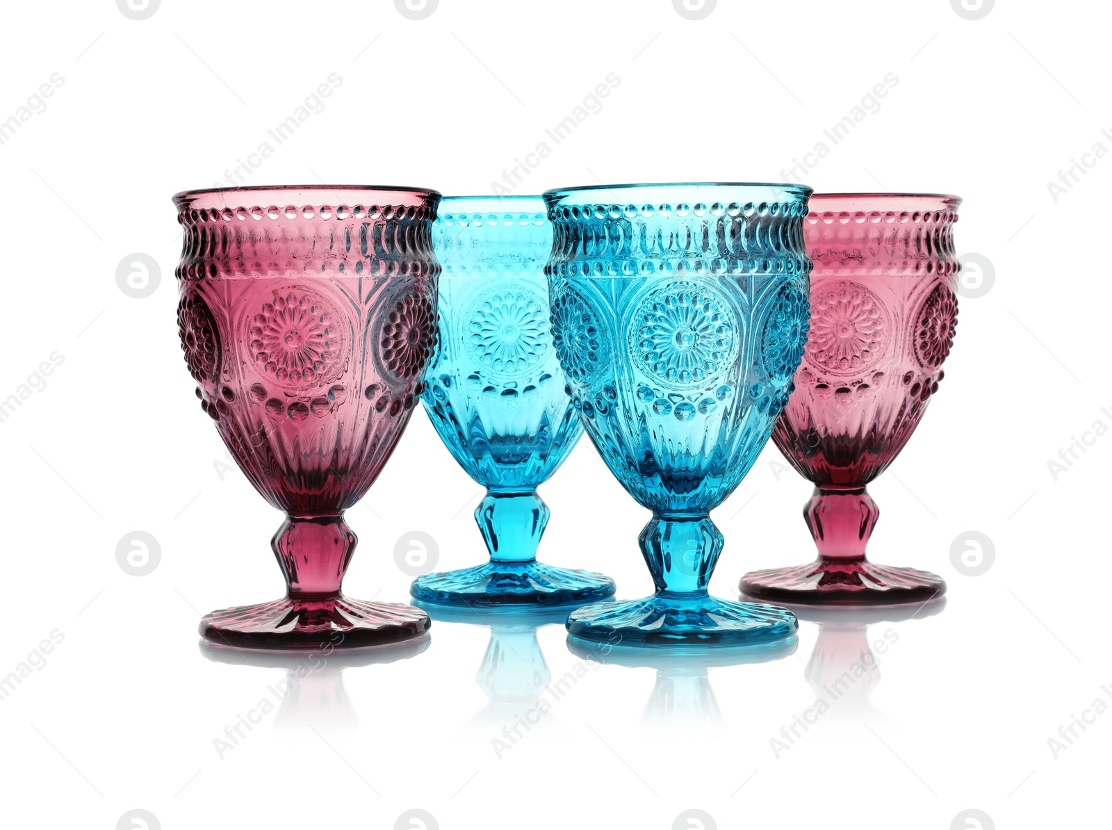 Photo of Empty elegant colorful glasses on white background