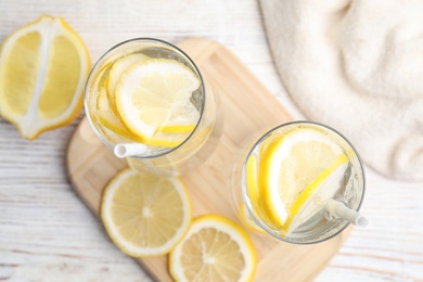 Soda water with lemon slices on white wooden table, flat lay