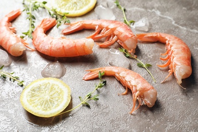 Fresh shrimps with lemon and thyme on gray background