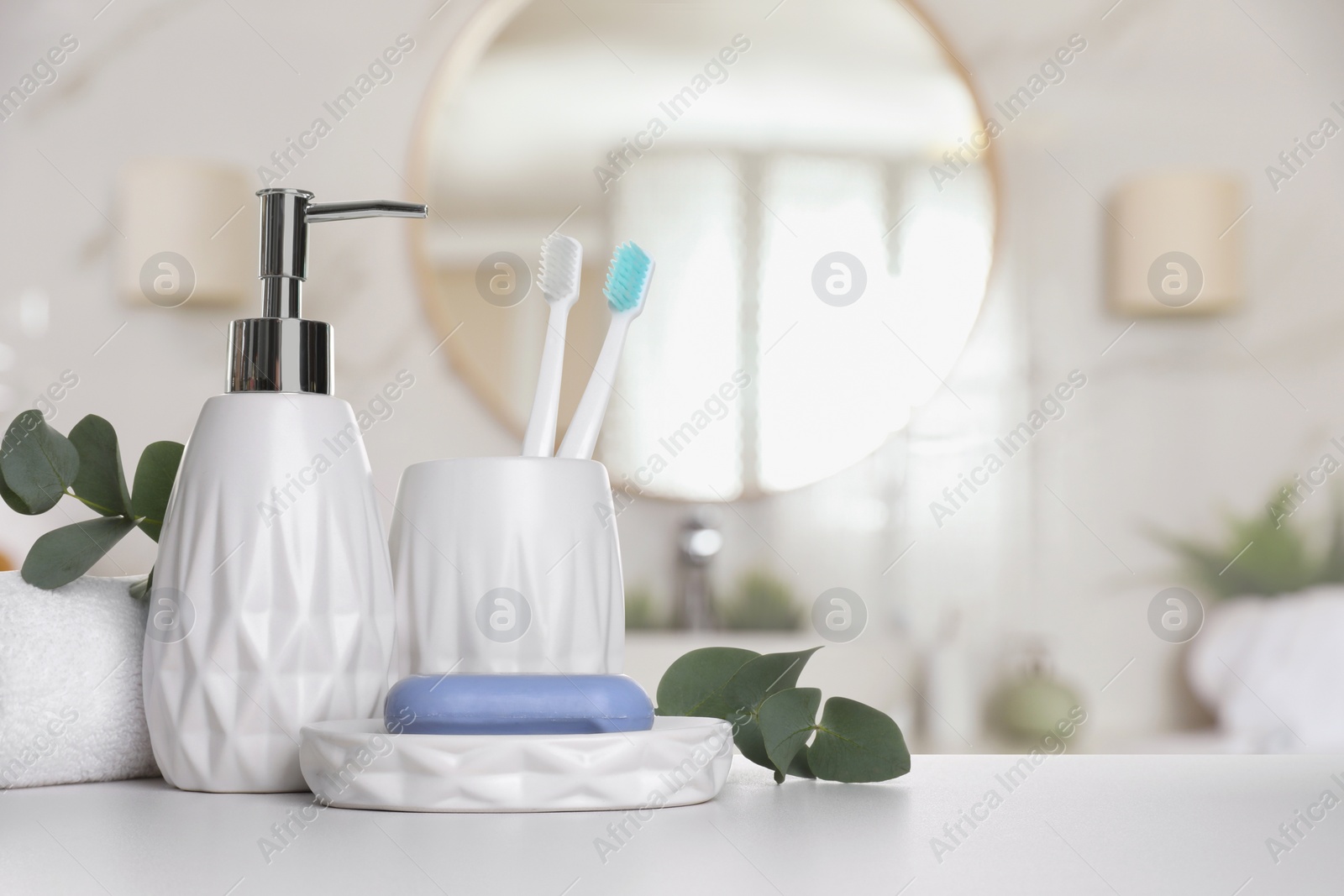Image of Bath accessories. Different personal care products and eucalyptus leaves on white table in bathroom, space for text