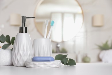Bath accessories. Different personal care products and eucalyptus leaves on white table in bathroom, space for text