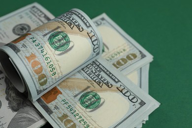 Photo of Money exchange. Dollar banknotes on green background, closeup