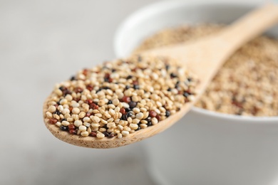 Wooden spoon with mixed quinoa seeds, closeup