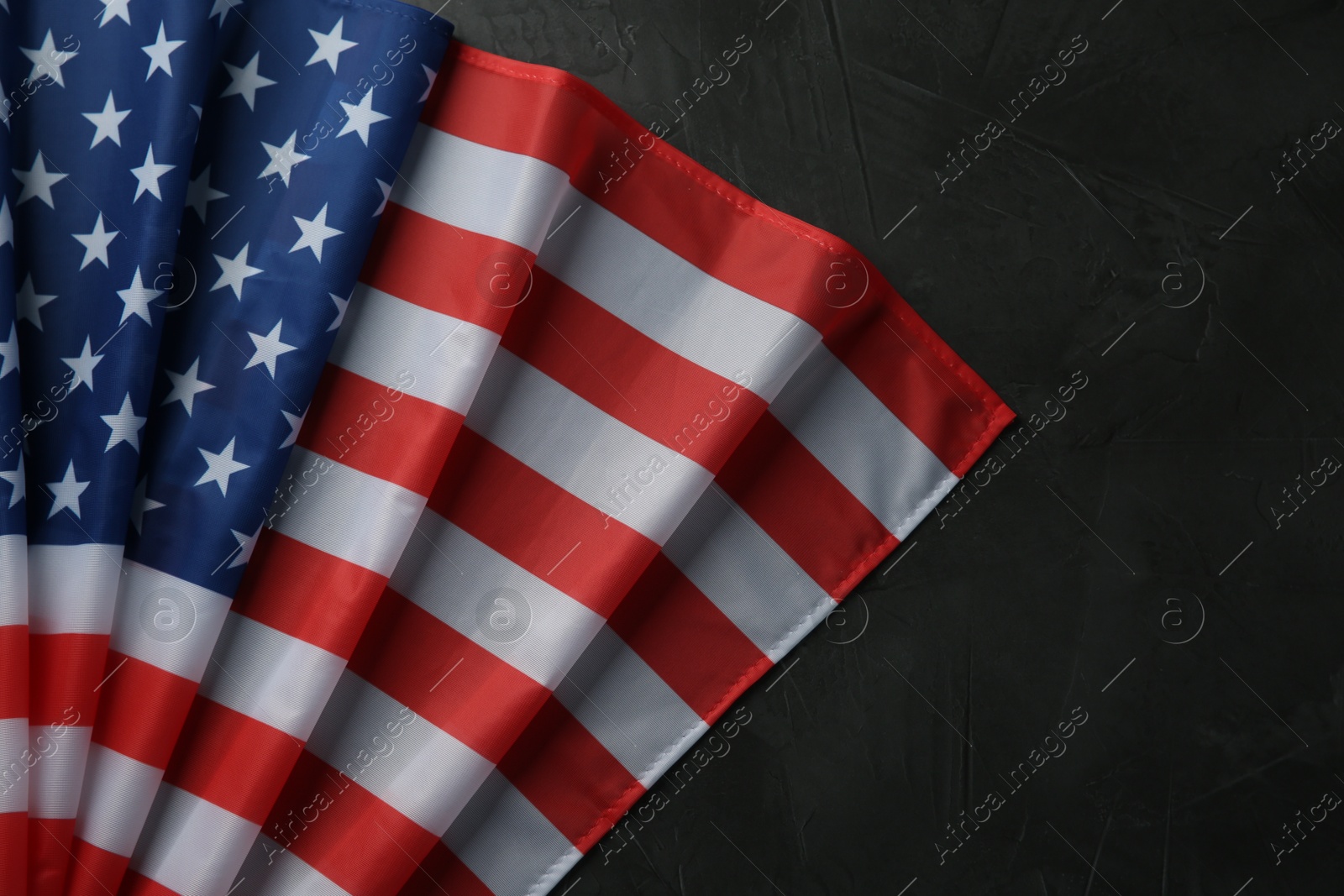 Photo of Flag of USA on black table, top view. Space for text