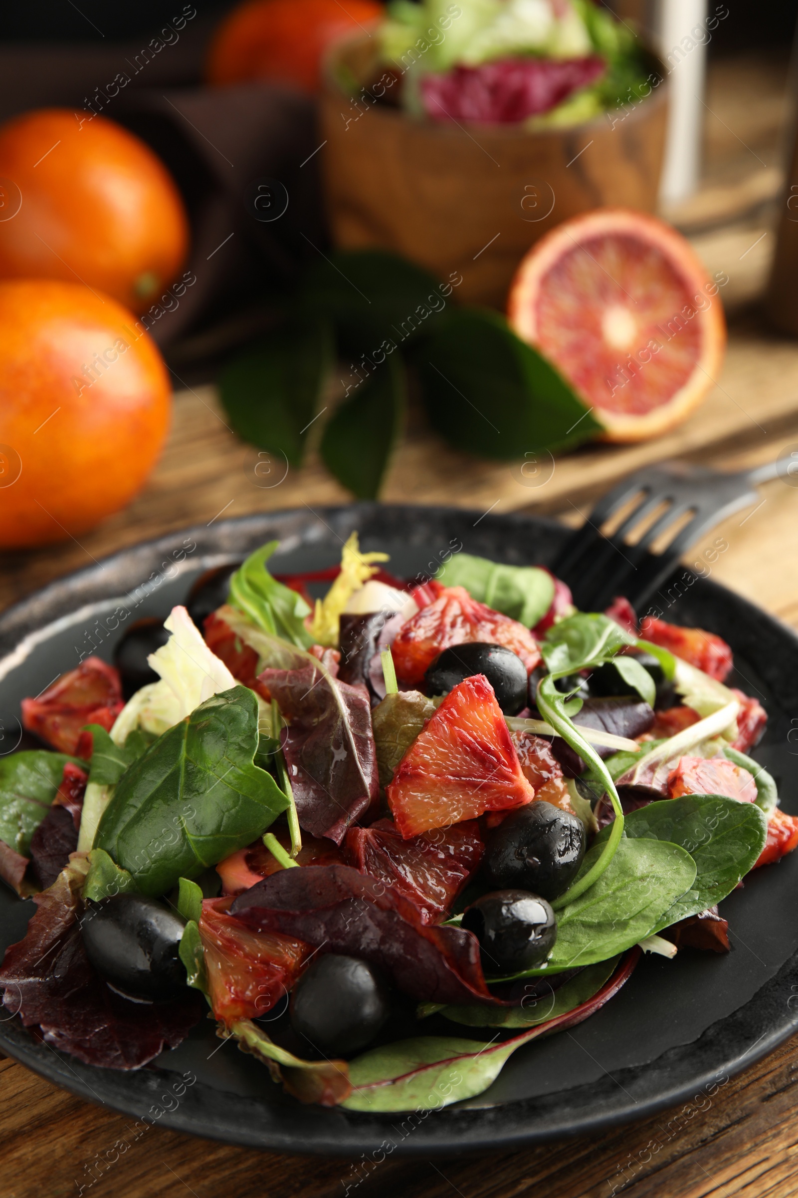 Photo of Delicious salad with sicilian orange on wooden table, closeup