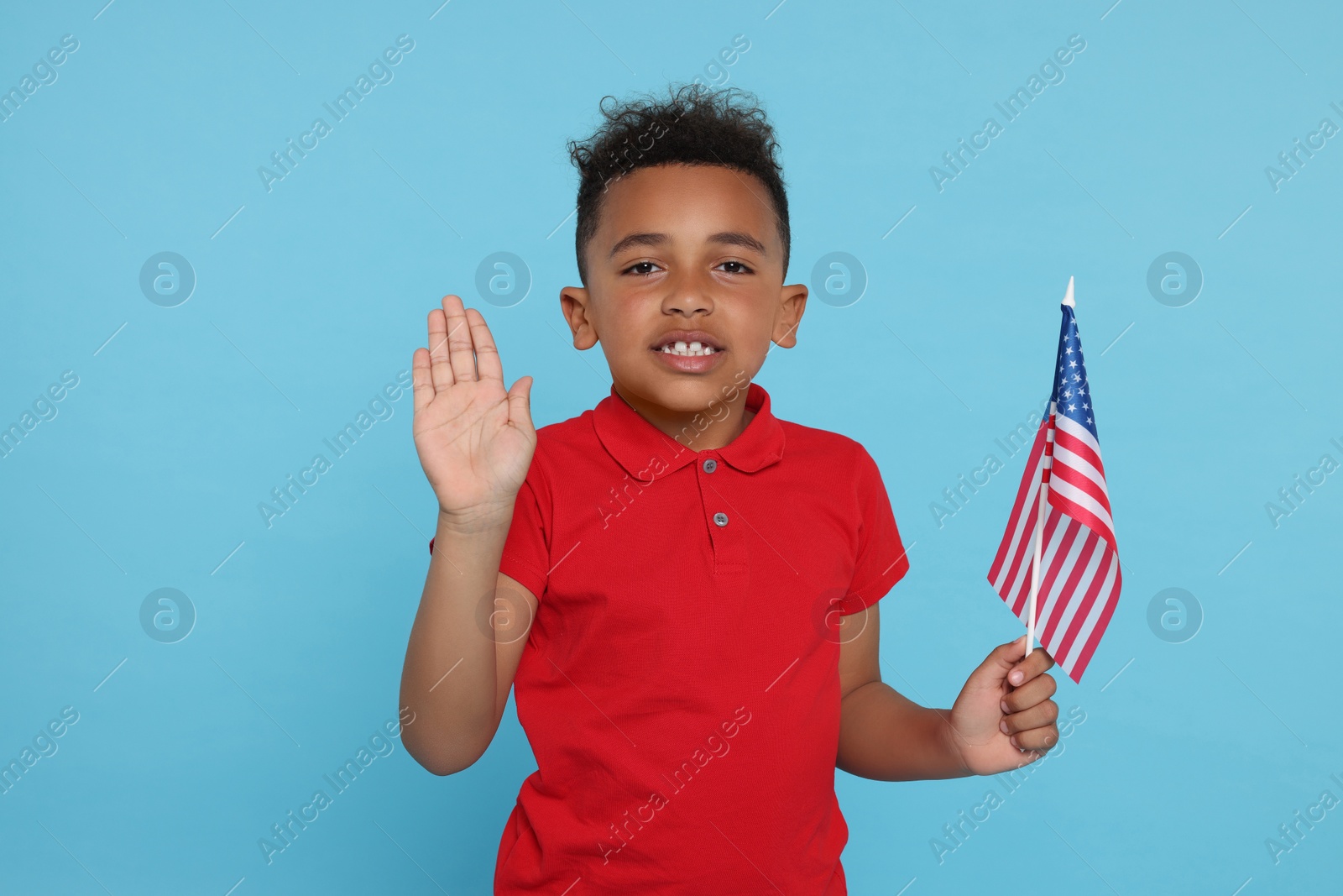 Photo of 4th of July - Independence Day of USA. Happy boy with American flag on light blue background