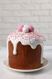 Tasty Easter cake with decorative sugar eggs on white marble table