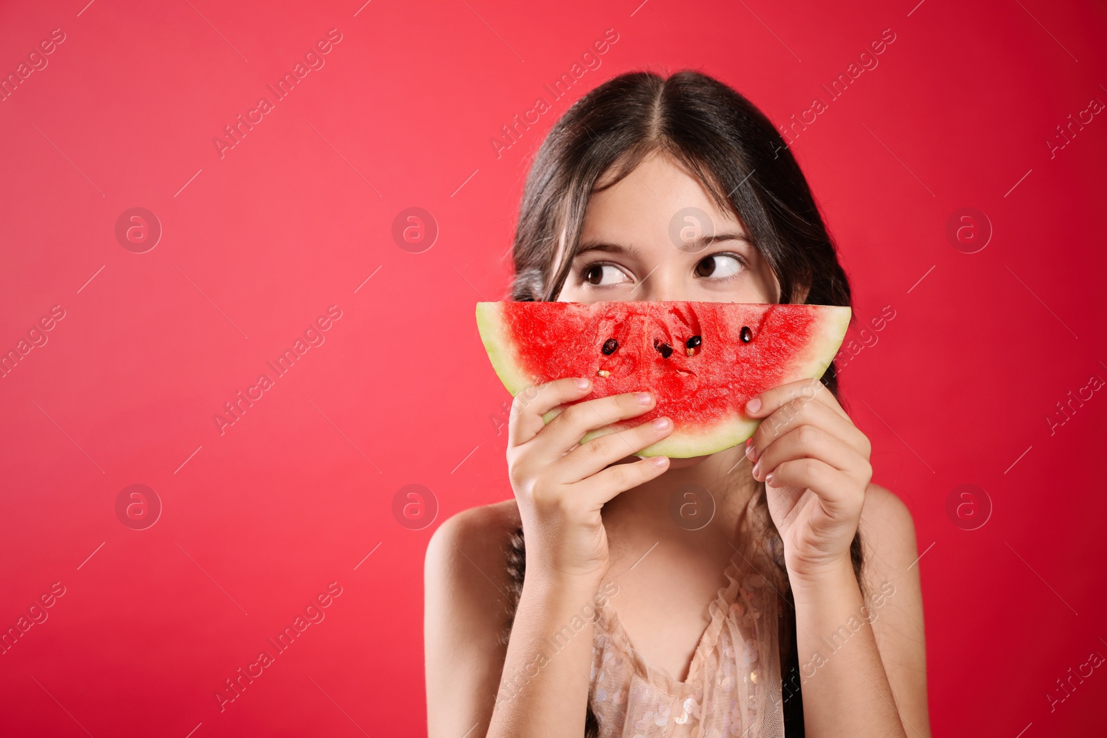 Photo of Cute little girl with watermelon on red background. Space for text