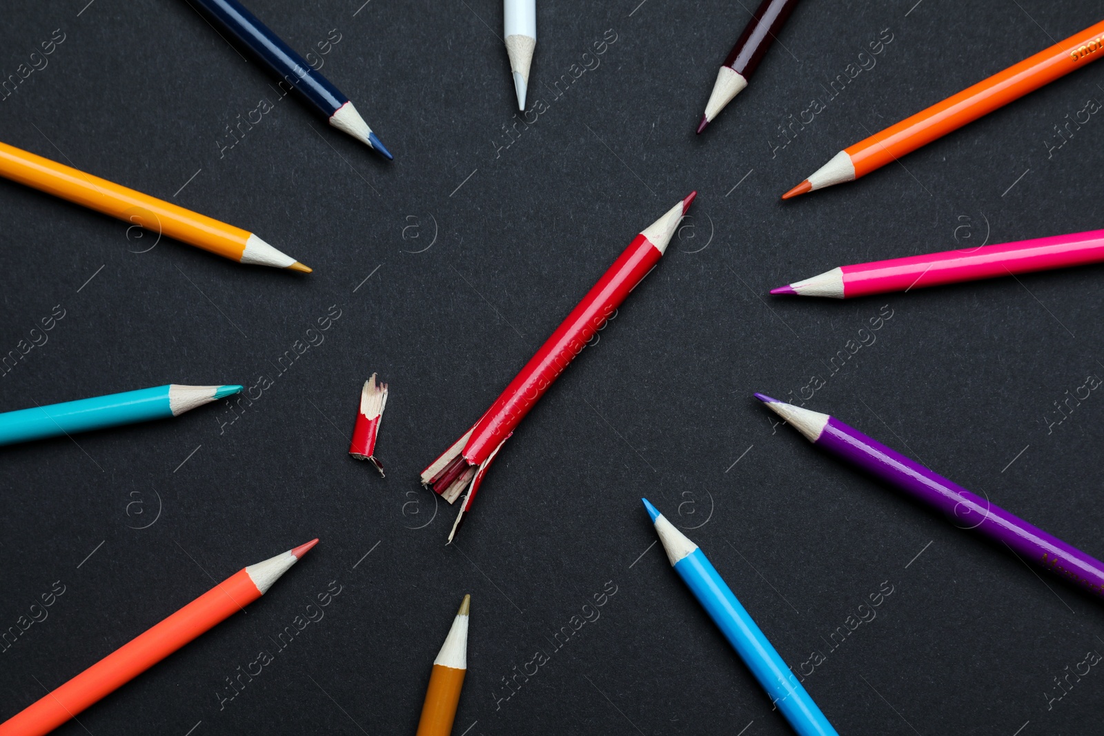 Photo of Whole colorful pencils and broken one on black background, flat lay. Bullying concept