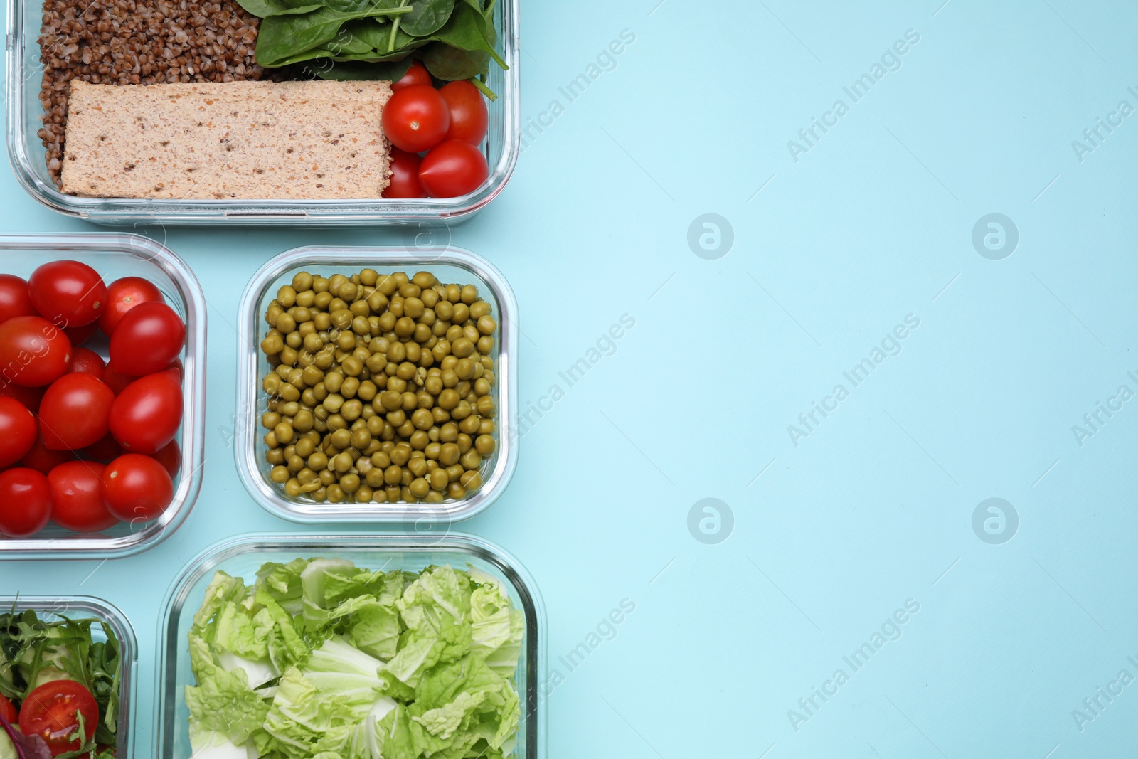 Photo of Glass containers with different fresh products on light blue background, flat lay. Space for text