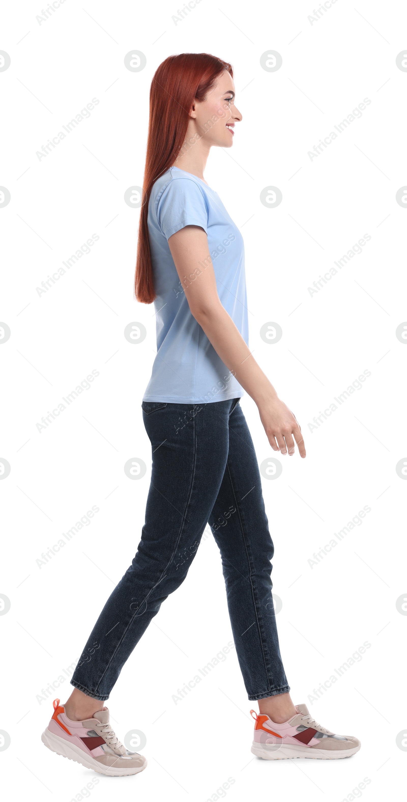 Photo of Happy woman with red dyed hair walking on white background