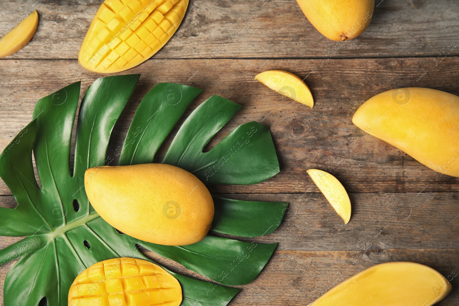 Photo of Flat lay composition with mango and tropical leaf on wooden background