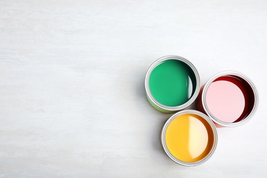 Photo of Cans with paint on light background, top view. Space for text