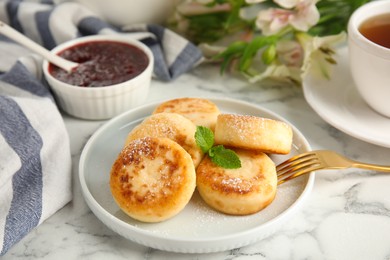 Delicious cottage cheese pancakes with mint and icing sugar on white marble table