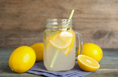 Photo of Cool freshly made lemonade and fruits on light blue wooden table