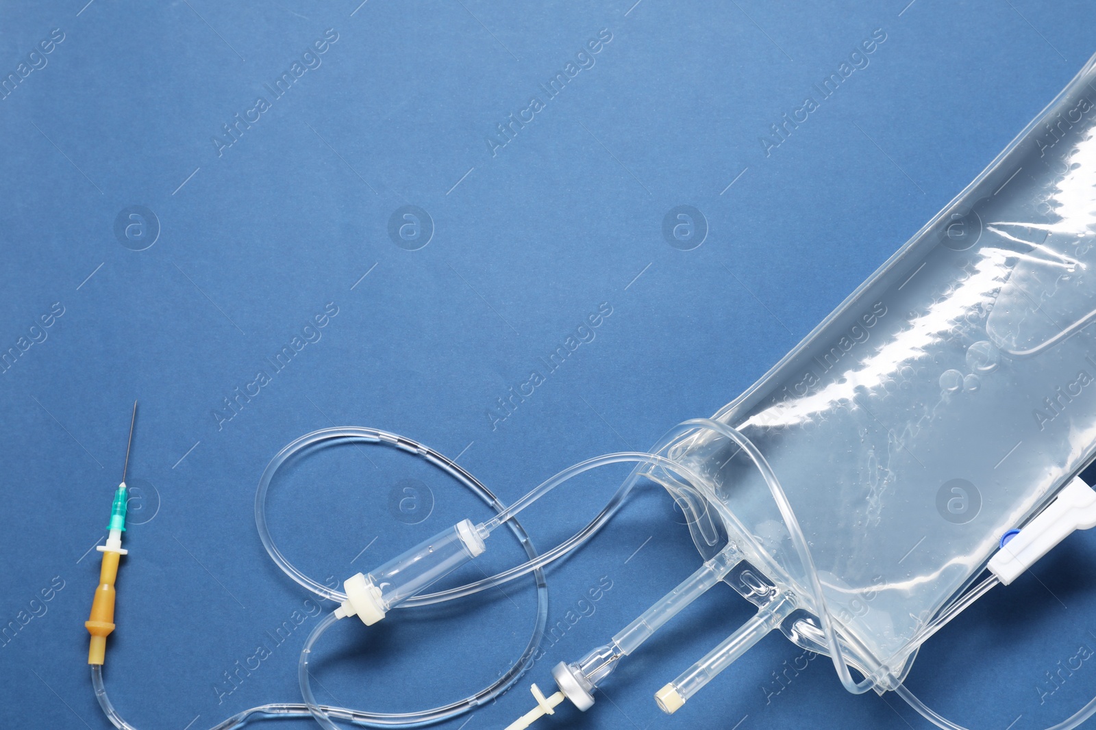 Photo of IV infusion set on blue background, top view. Space for text