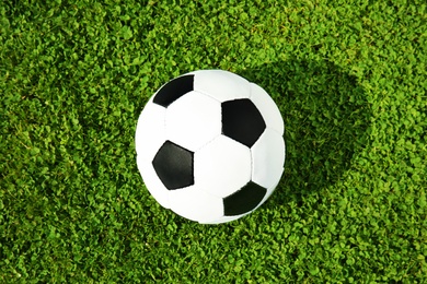 Photo of Soccer ball on fresh green football field grass, top view