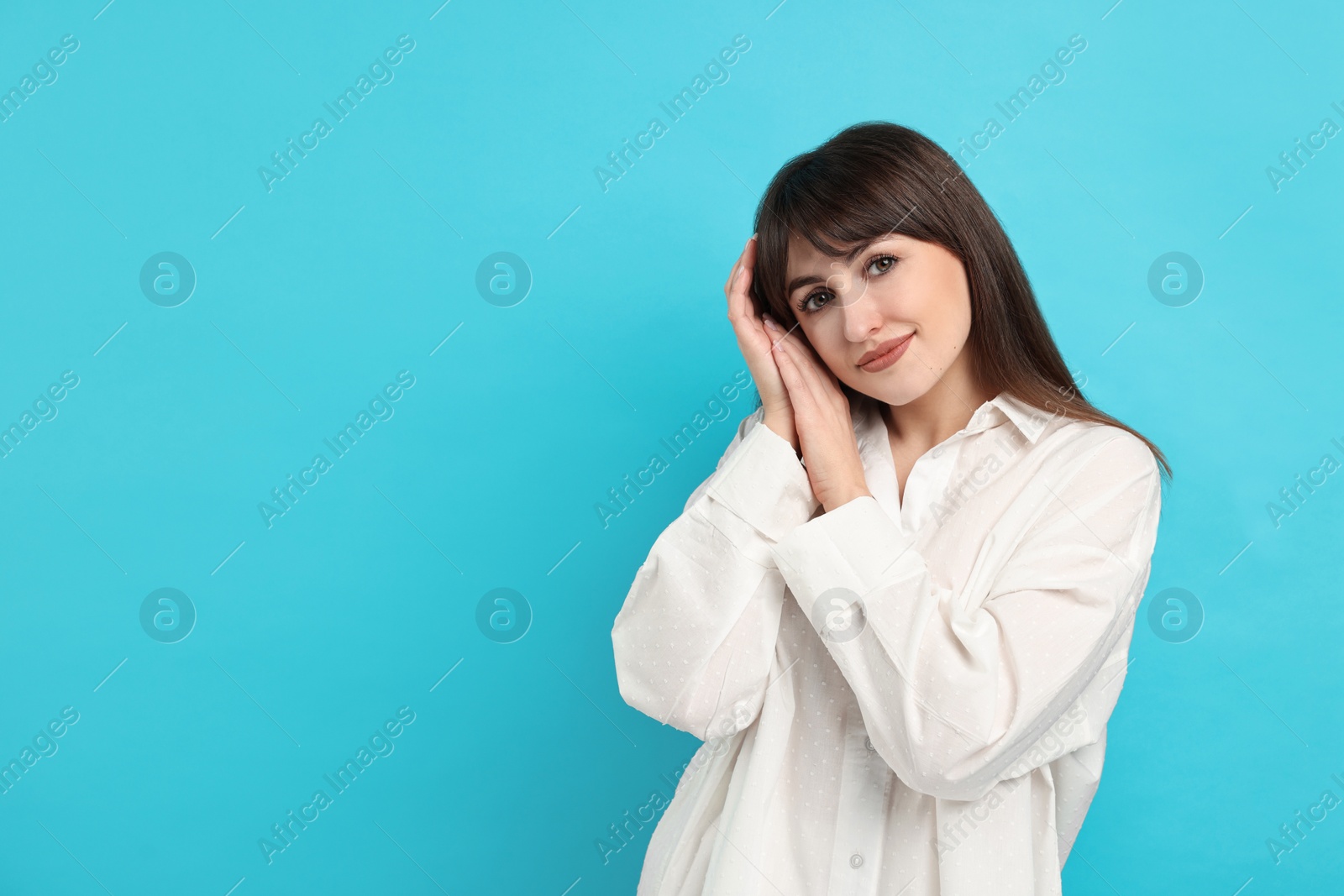 Photo of Woman wearing pyjama on light blue background, space for text