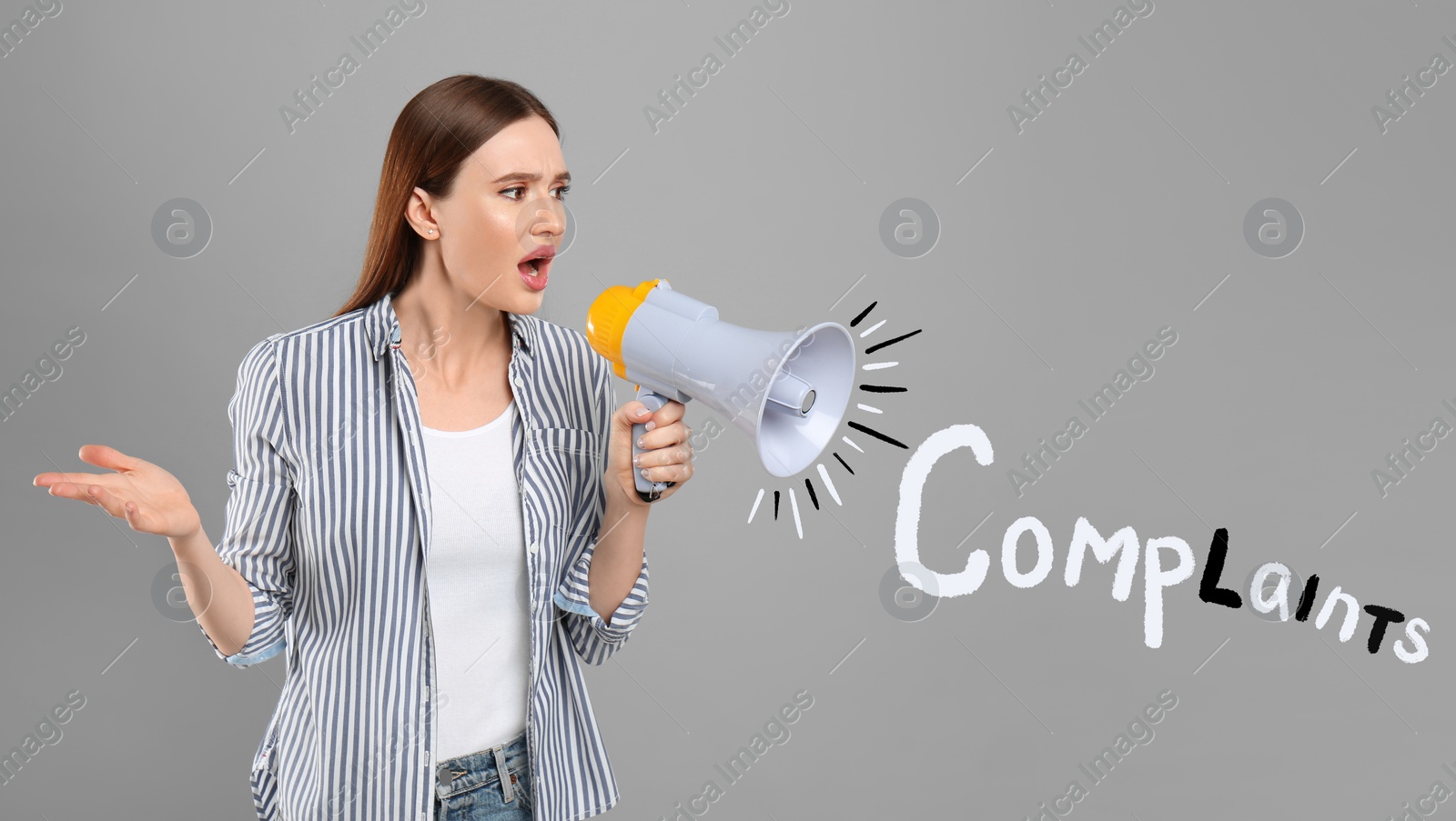 Image of Emotional young woman with megaphone and word Complaint on light grey background