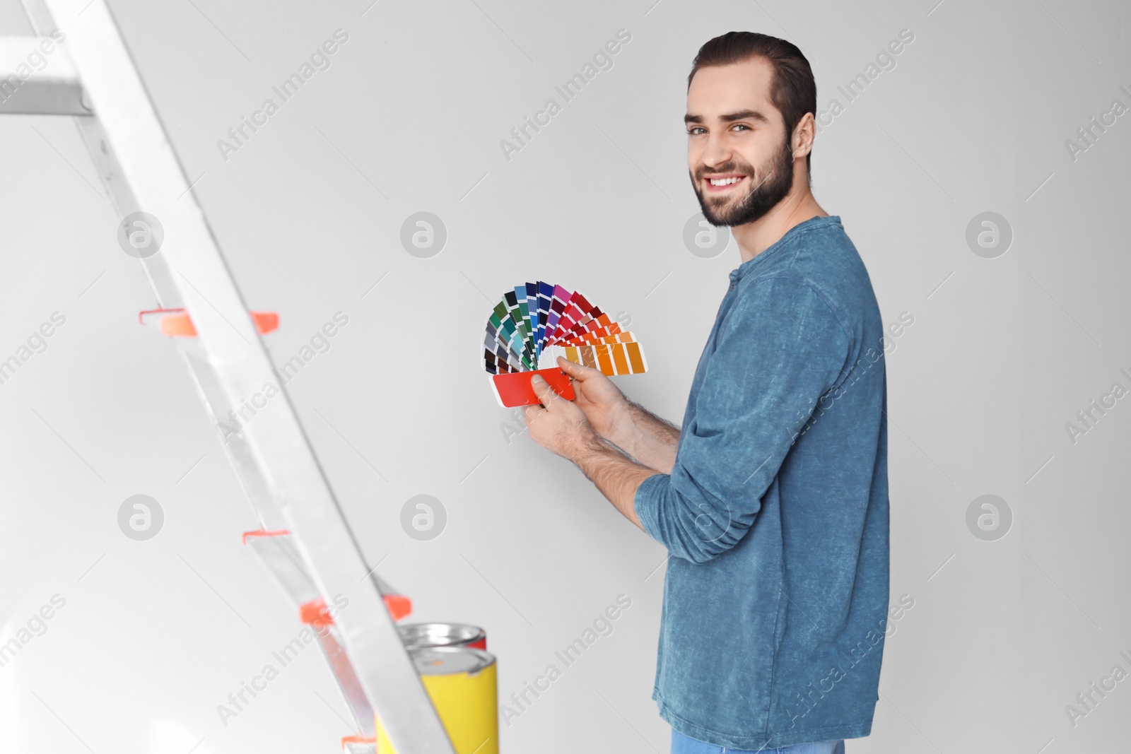 Photo of Young man with color palette on white background