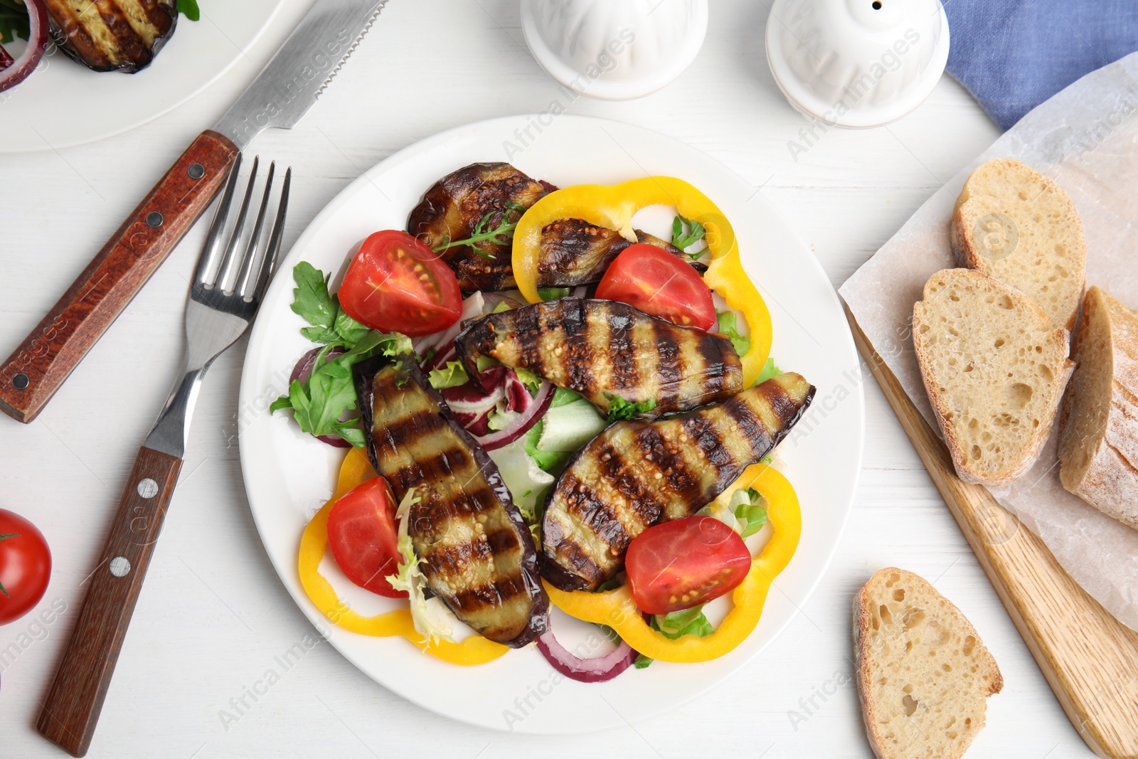 Photo of Delicious salad with roasted eggplant served on white wooden table, flat lay