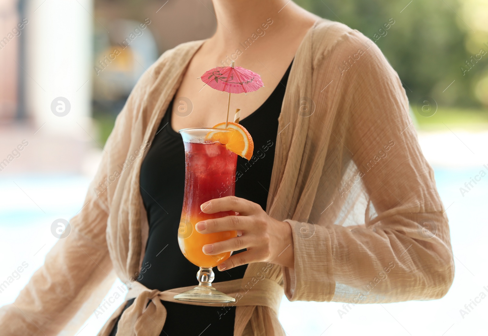 Photo of Woman holding glass with delicious cocktail outdoors