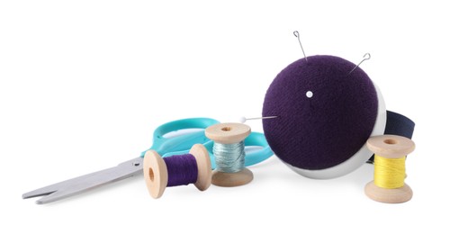 Pincushion, sewing needles, pins, spools of threads and scissors isolated on white