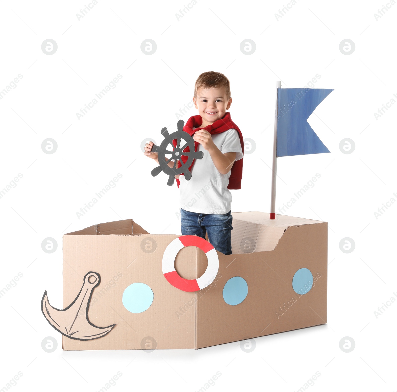 Photo of Cute little boy playing with cardboard ship on white background