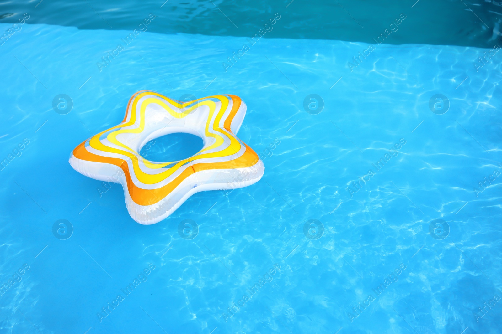 Photo of Inflatable ring floating in swimming pool on sunny day