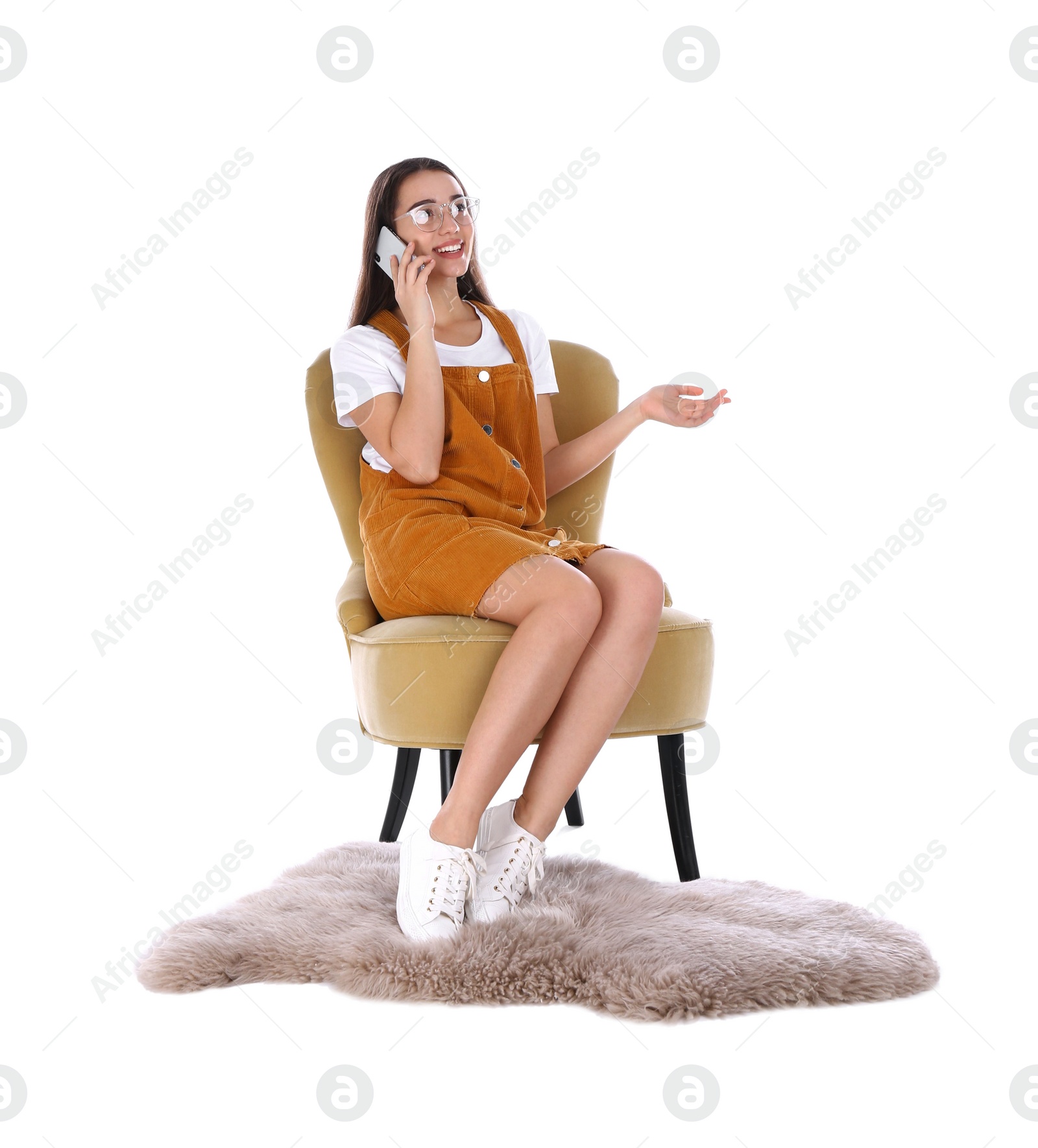 Photo of Young woman talking by phone in armchair isolated on white