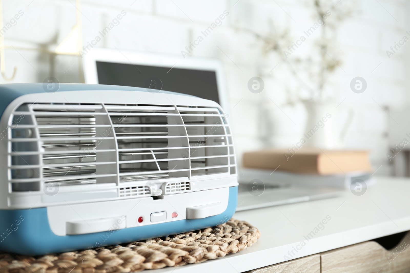 Photo of Modern air purifier on white wooden table in room, closeup