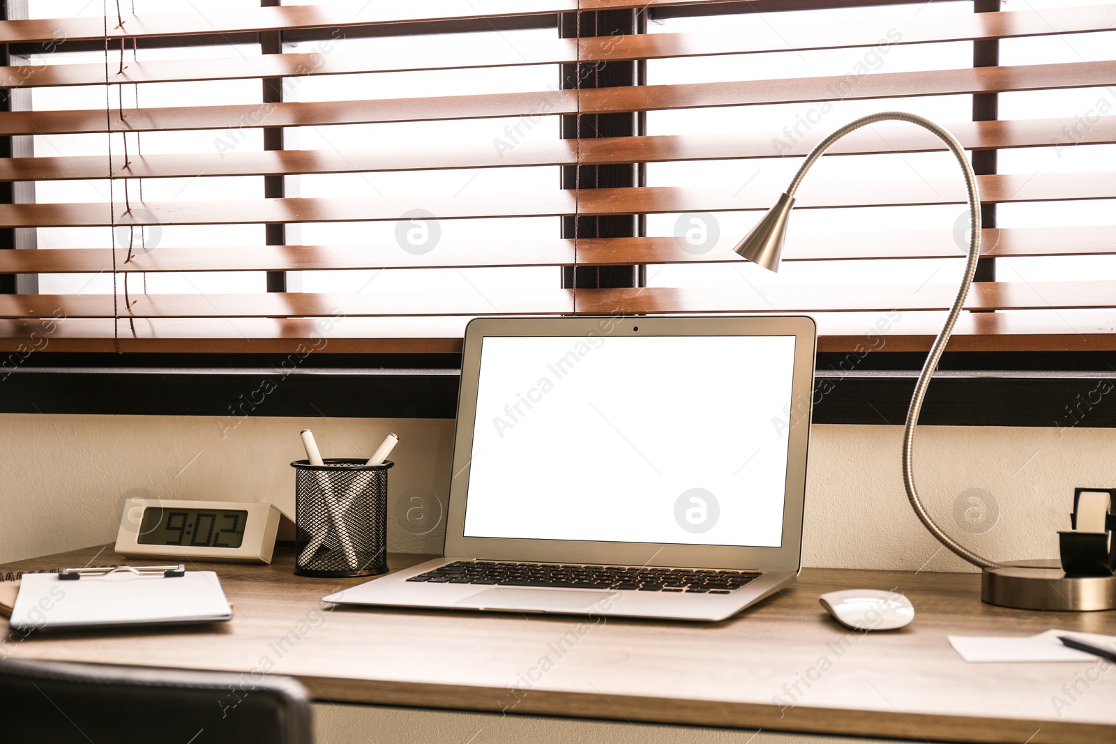 Photo of Modern laptop on table in office. Comfortable workplace