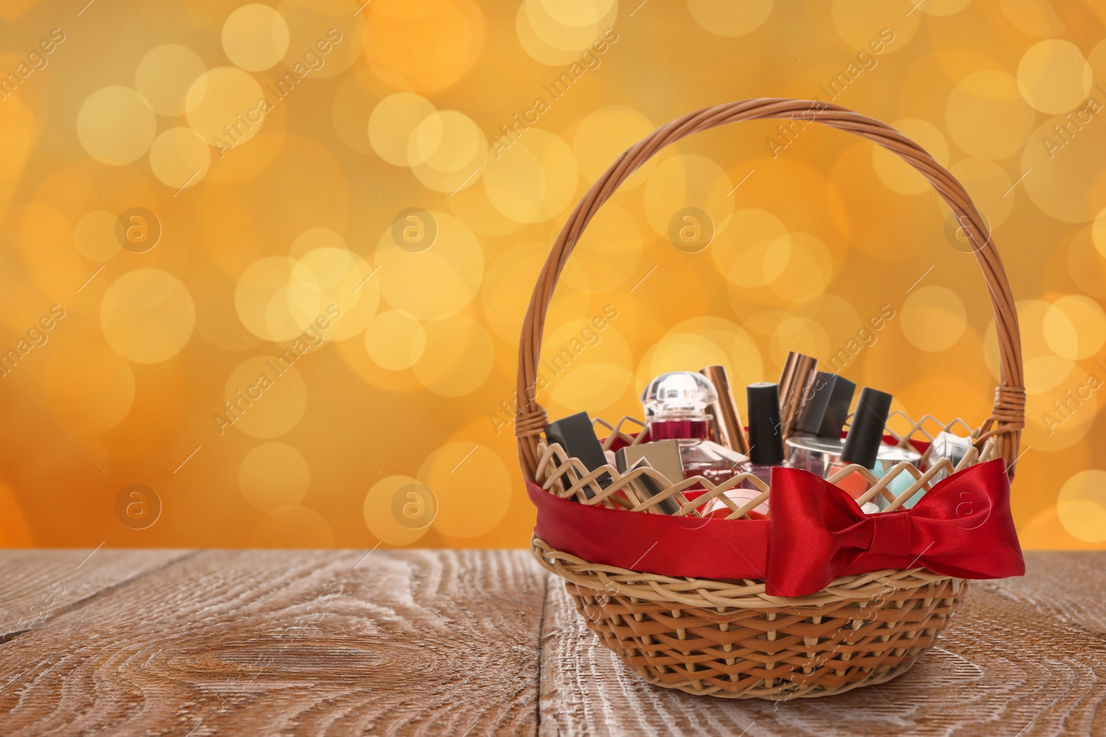 Image of Wicker basket full of cosmetic products on table against blurred festive lights. Space for text