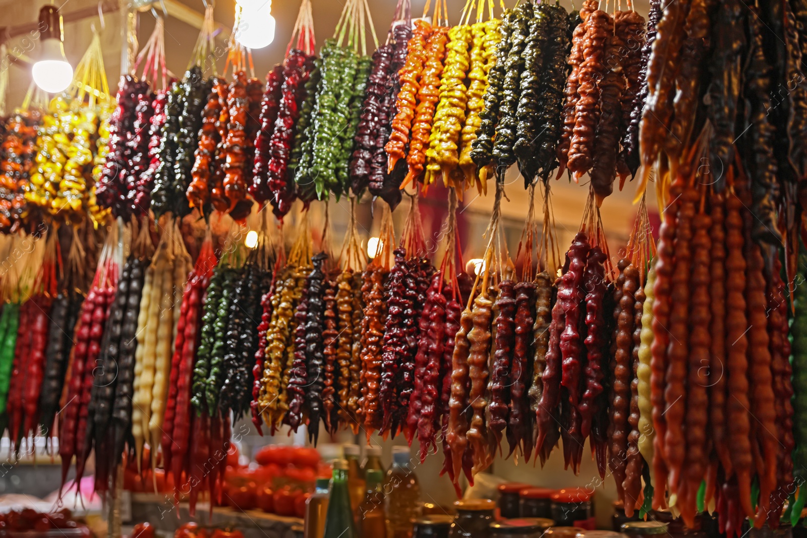 Photo of Bunches of different delicious churchkhelas at market