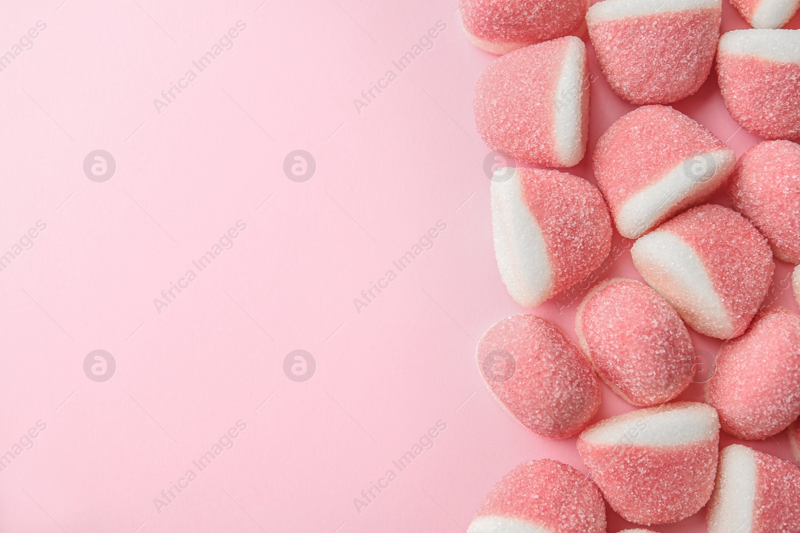 Photo of Sweet jelly candies on pink background, top view. Space for text