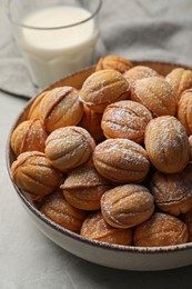 Photo of Bowl of delicious nut shaped cookies on grey table, closeup