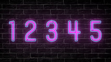 Glowing neon number (1, 2, 3, 4, 5) signs on brick wall