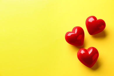 Photo of Red hearts on yellow background, flat lay. Space for text
