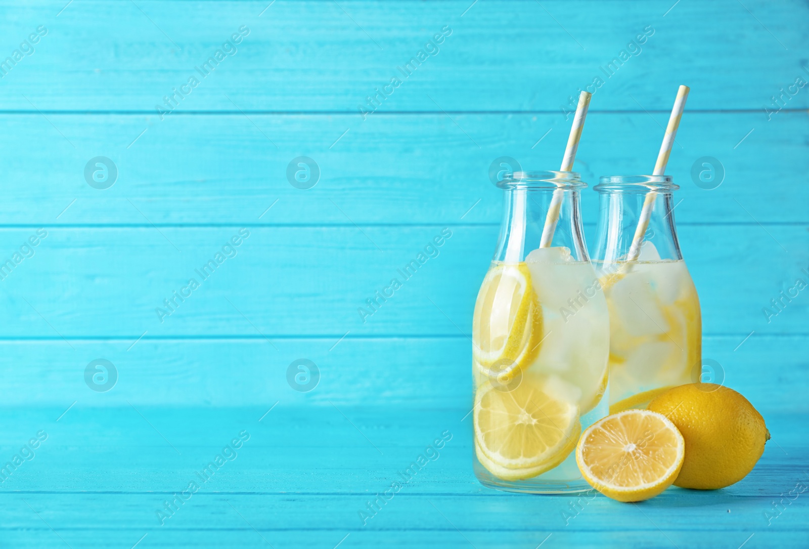 Photo of Natural lemonade in bottles on wooden table