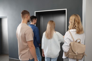 Photo of Group of people waiting for elevator in modern building