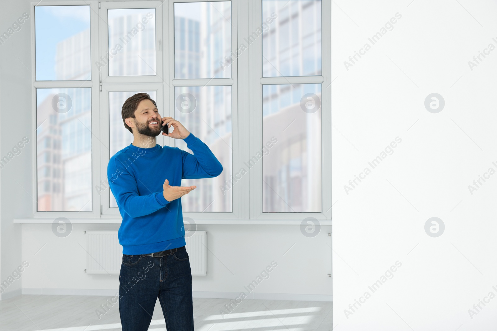 Photo of Man in casual clothes talking on phone indoors, space for text