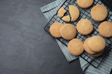 Photo of Delicious sugar cookies on black table, top view. Space for text