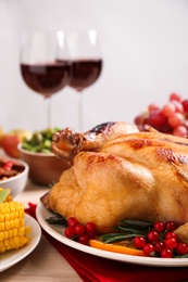 Photo of Traditional Thanksgiving day feast with delicious cooked turkey and other seasonal dishes served on table, closeup