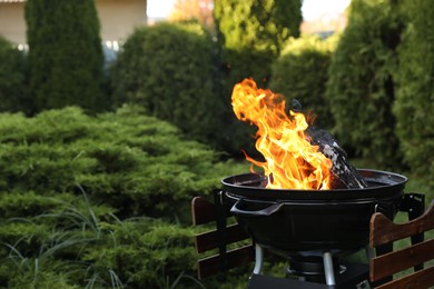 Portable barbecue grill with fire flames outdoors. Space for text