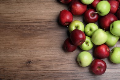 Fresh ripe red and green apples on wooden table, flat lay. Space for text