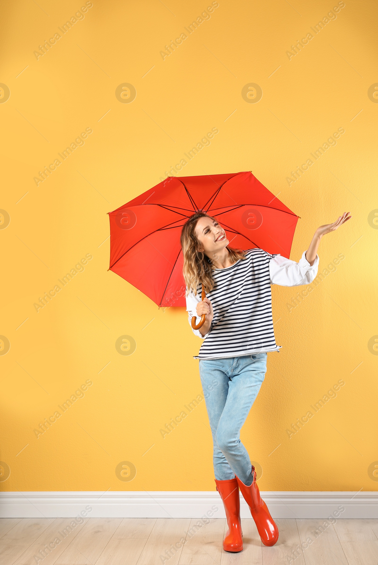 Photo of Woman with red umbrella near color wall