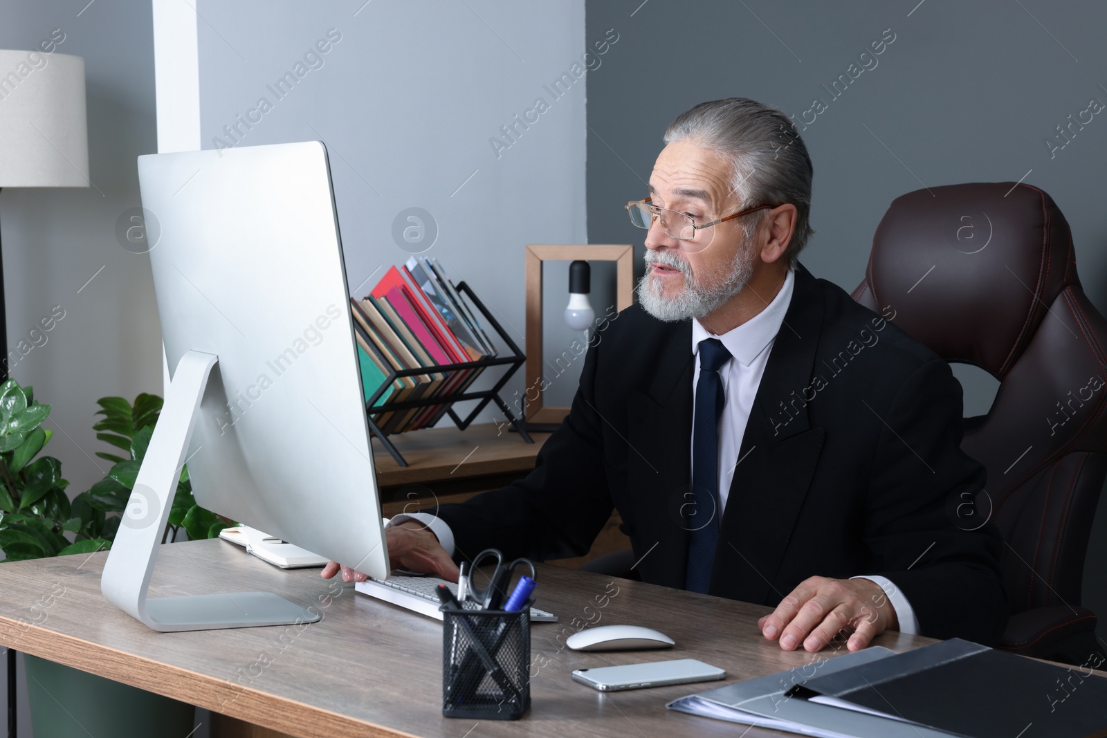 Photo of Successful senior boss working in his office