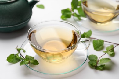 Photo of Aromatic herbal tea with mint on white table